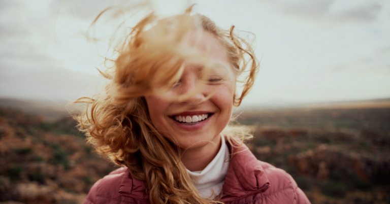 Junge Frau, lachend, ihr Haar weht im Wind